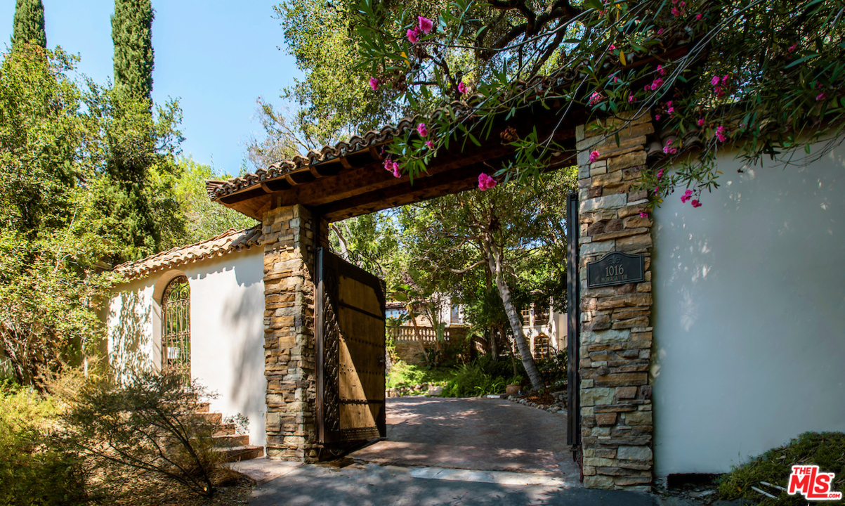 1016 Moraga Drive Los Angeles, CA 90049 - Photo 3 of 30 a view of a house with a yard and tree s