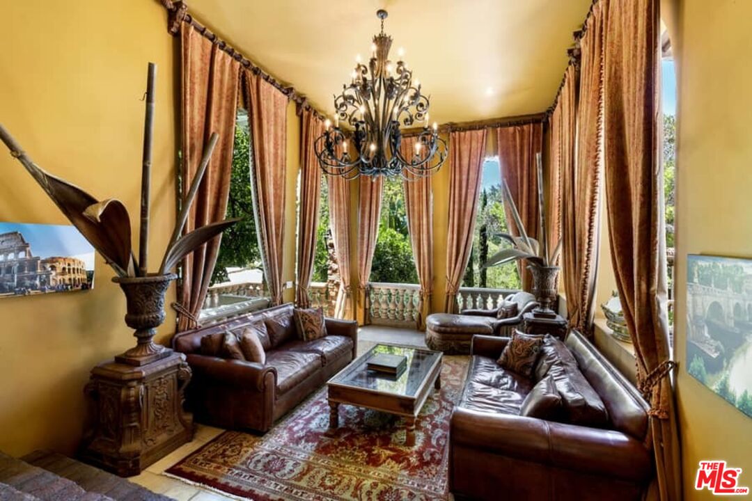 1016 Moraga Drive Los Angeles, CA 90049 - Photo 10 of 30 a living room with fireplace furniture and floor to ceiling windows