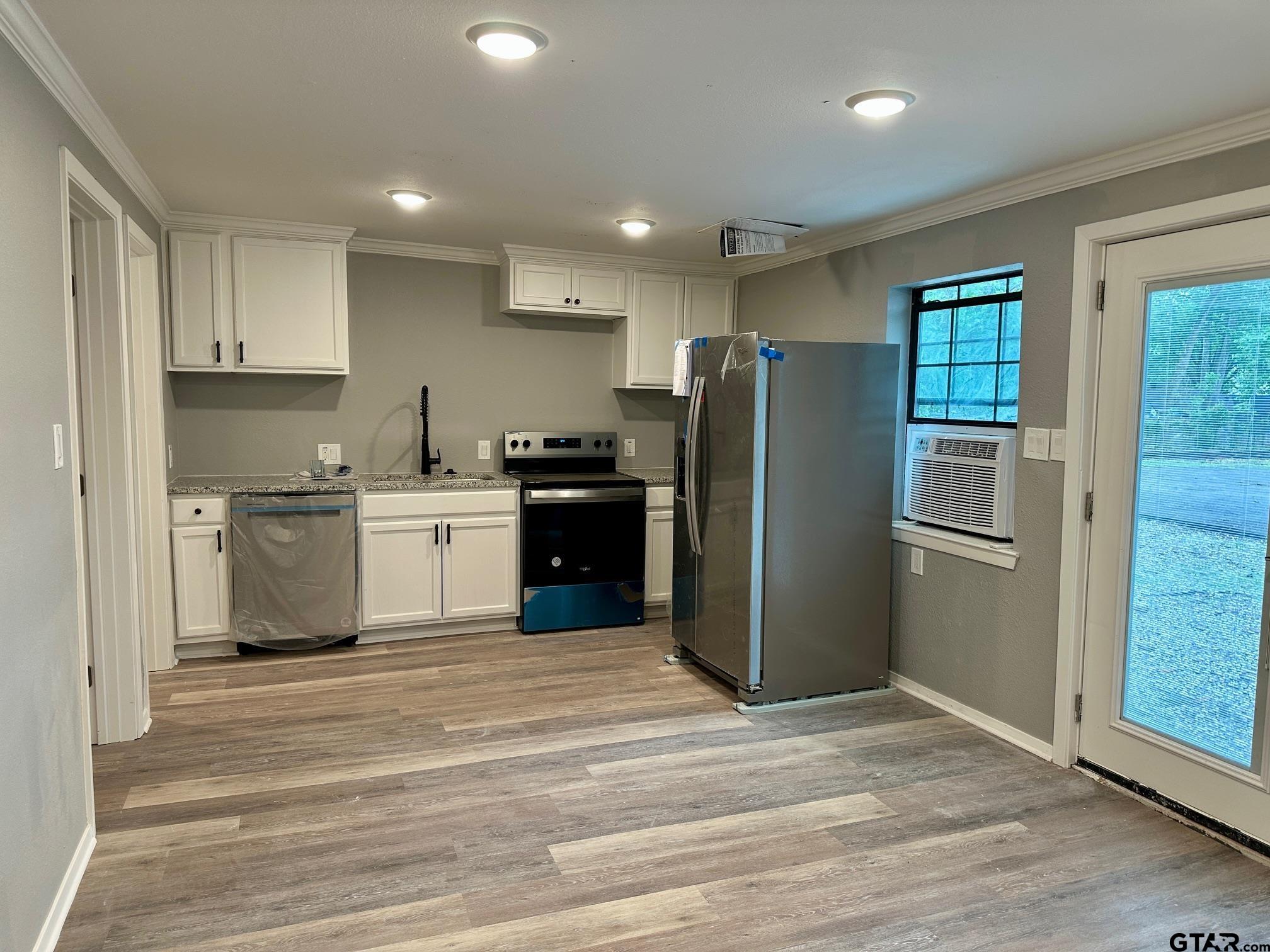 a kitchen with stainless steel appliances granite countertop a refrigerator a stove a sink and a microwave