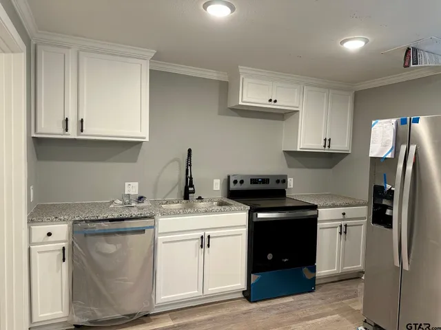a kitchen with stainless steel appliances granite countertop a sink stove and refrigerator