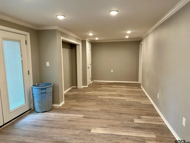 a view of a big room with wooden floor and a window