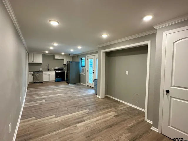 a view of empty room with wooden floor