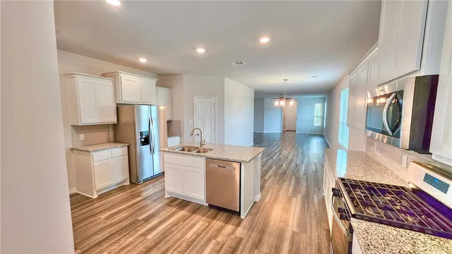 a kitchen with stainless steel appliances a refrigerator and a stove top oven