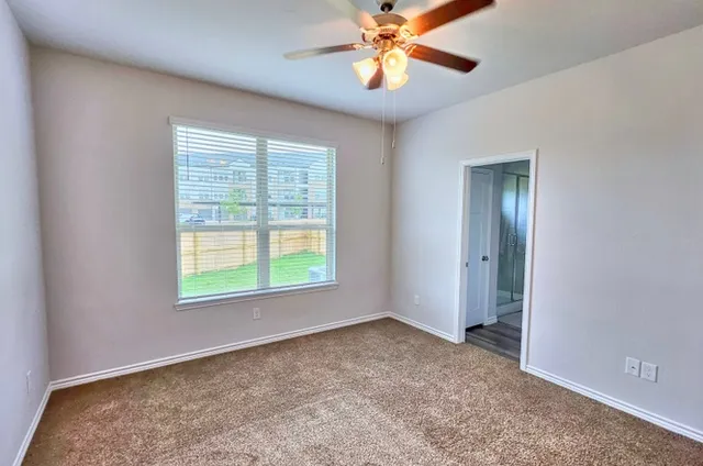 an empty room with a window and a fan