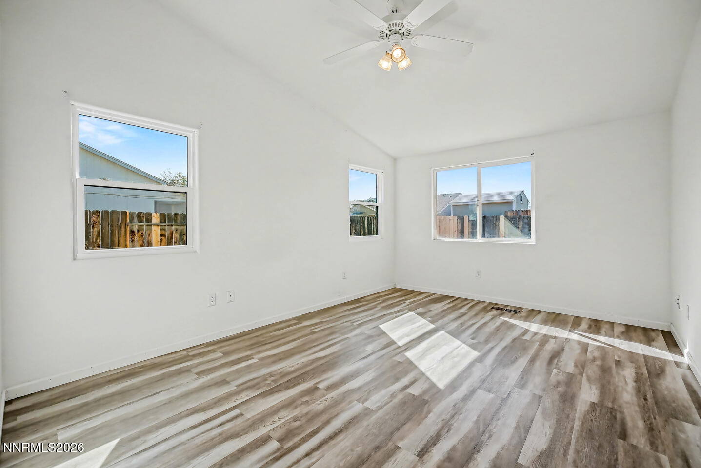 133 Prairie Lane Fernley, NV 89408 - Photo 13 of 22 a view of empty room with wooden floor and fan