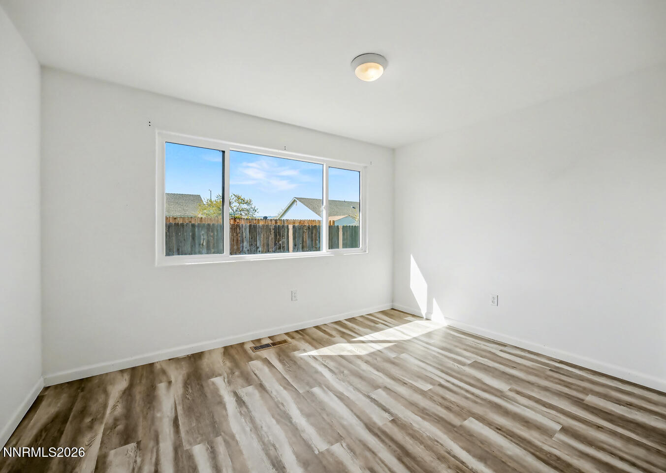 133 Prairie Lane Fernley, NV 89408 - Photo 10 of 22 a view of empty room with wooden floor and fan