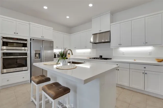 a kitchen with stainless steel appliances kitchen island granite countertop a sink and cabinets