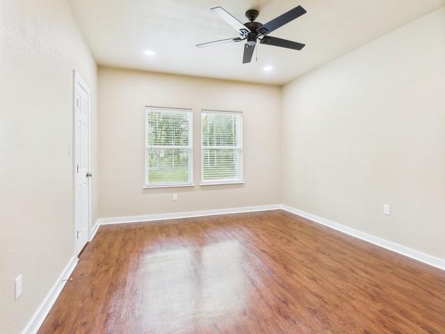 910 Cream Level Road Athens, TX 75751 - Photo 15 of 40 an empty room with wooden floor fan and windows