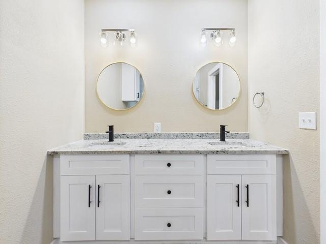 910 Cream Level Road Athens, TX 75751 - Photo 22 of 40 a bathroom with a granite countertop double vanity sinks and a mirror