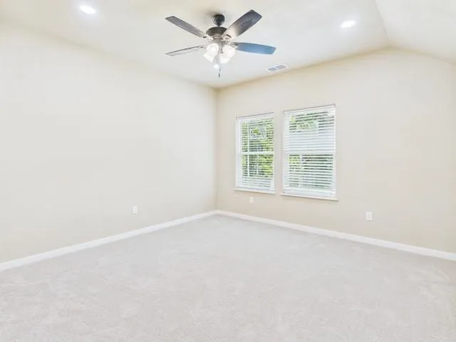 an empty room with a window and a fan