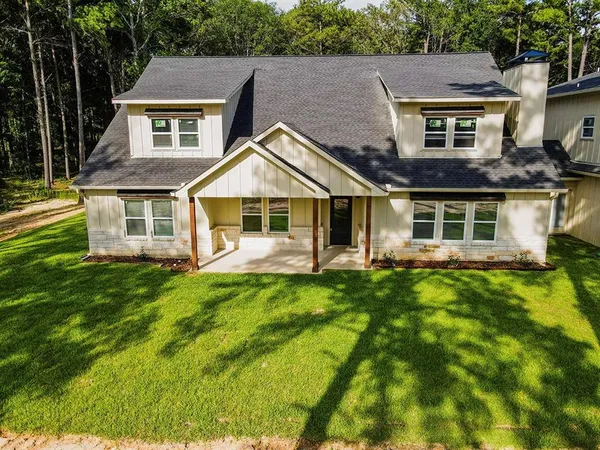 an aerial view of residential houses with yard and trees