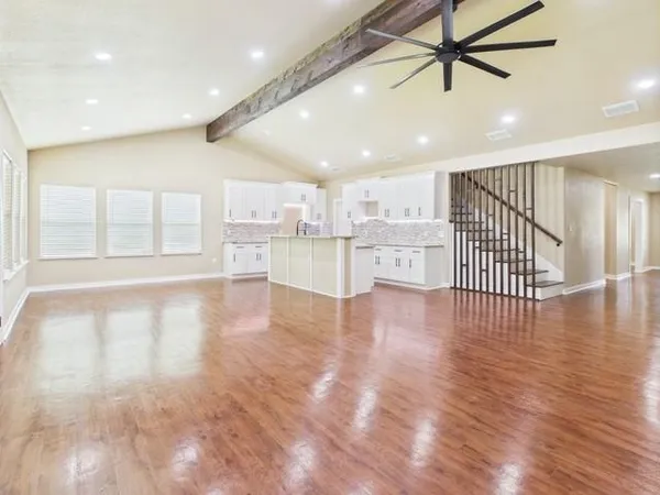 a view of a kitchen with refrigerator and wooden floor