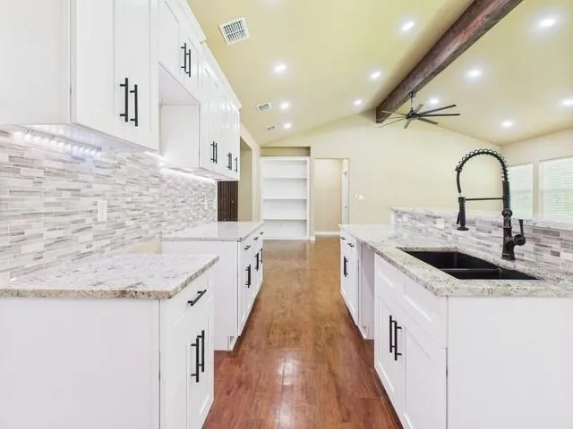 a large kitchen with stainless steel appliances granite countertop a sink and cabinets