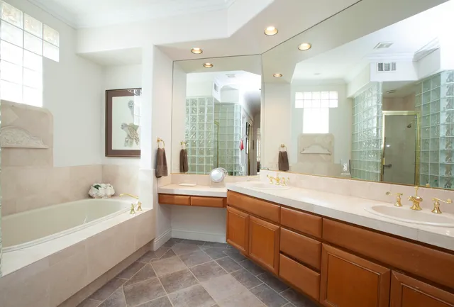 a bathroom with a tub double sink window and mirror