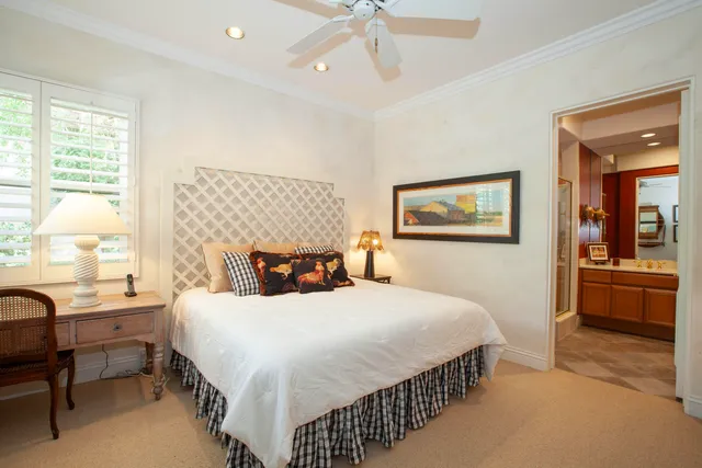 a bedroom with a bed a chandelier and a dresser