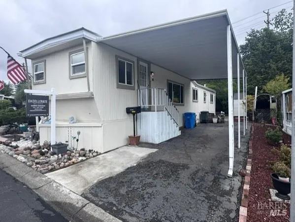 a view of a white house next to a road