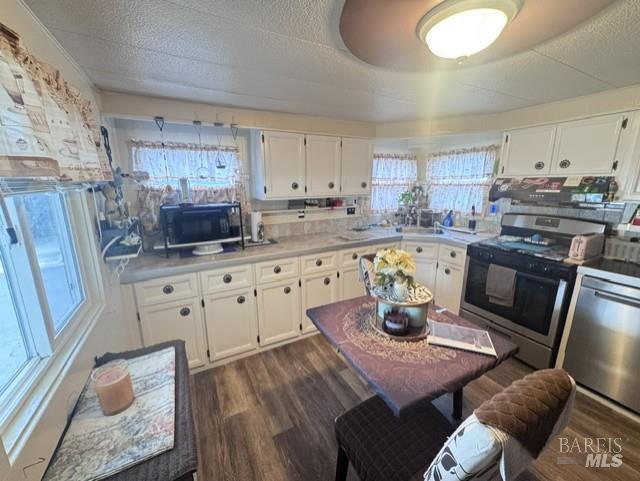 139 Coronado Circle Santa Rosa, CA 95409 - Photo 6 of 23 a kitchen with stainless steel appliances granite countertop a stove a sink dishwasher and white cabinets with wooden floor