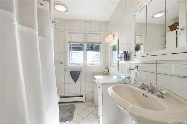 a bathroom with a double vanity sink a mirror and a bathtub