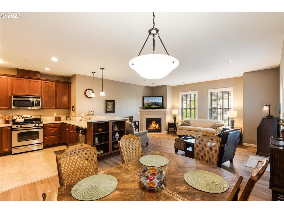 1258 Northwest Shattuck Way, Unit 309 Gresham, OR 97030 - Photo 12 of 33 a living room with furniture a dining table and a fireplace