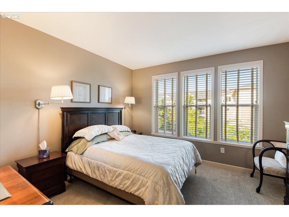 1258 Northwest Shattuck Way, Unit 309 Gresham, OR 97030 - Photo 24 of 33 a bedroom with a bed chair and a large window