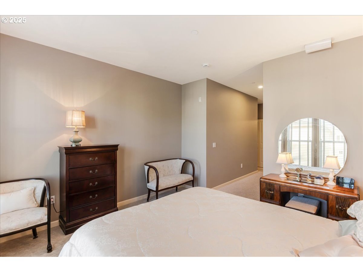 1258 Northwest Shattuck Way, Unit 309 Gresham, OR 97030 - Photo 26 of 33 a bedroom with a bed and a dresser with mirror