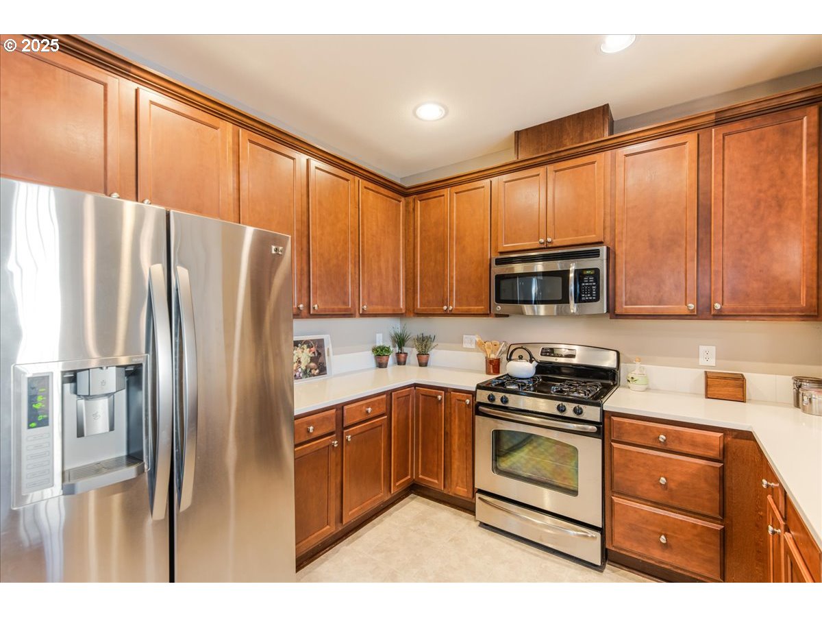 1258 Northwest Shattuck Way, Unit 309 Gresham, OR 97030 - Photo 10 of 33 a kitchen with stainless steel appliances granite countertop a refrigerator stove and microwave