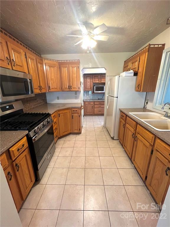 2525 Holbrook Road Fort Mill, SC 29715 - Photo 3 of 29 a kitchen with stainless steel appliances a sink a stove top oven a counter space and cabinets