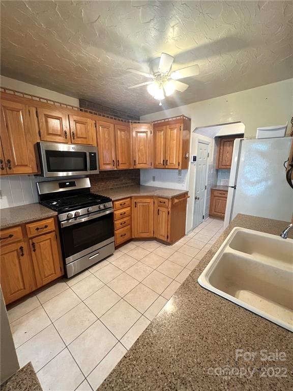 2525 Holbrook Road Fort Mill, SC 29715 - Photo 4 of 29 a kitchen with granite countertop a stove a sink and a microwave
