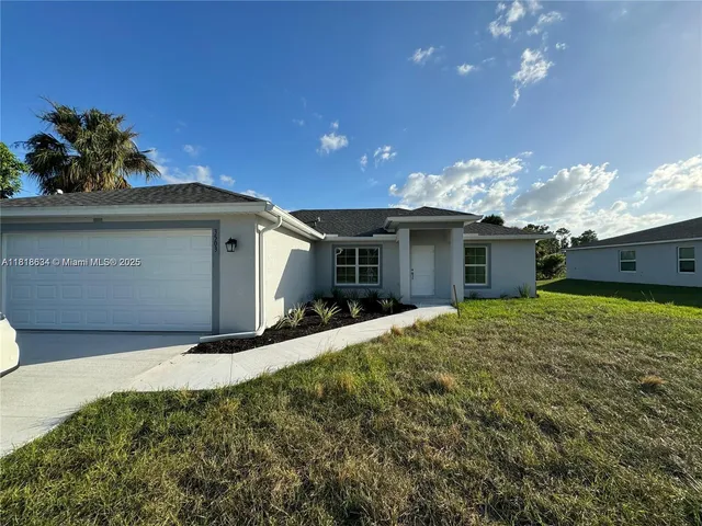 a front view of a house with a yard and garage