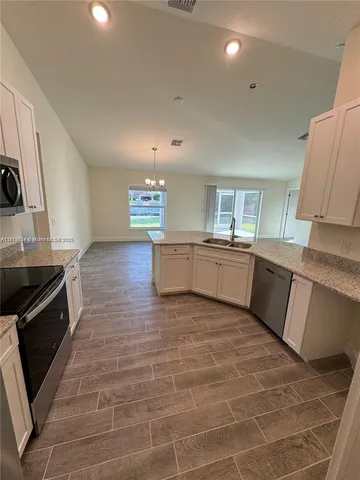 a kitchen with granite countertop a sink and a stove top oven