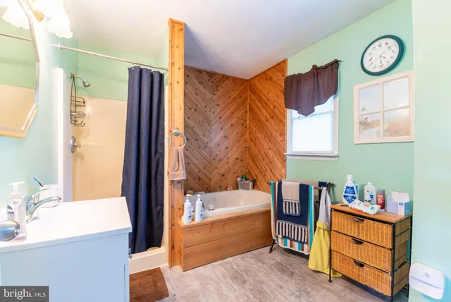 a bathroom with a tub sink and mirror