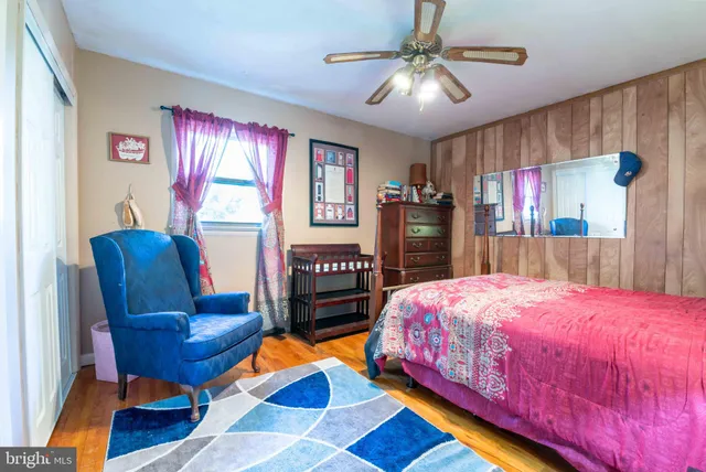 a bedroom with a bed and dresser with mirror