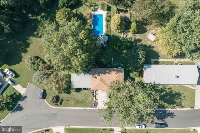 an aerial view of a house with a yard and trees