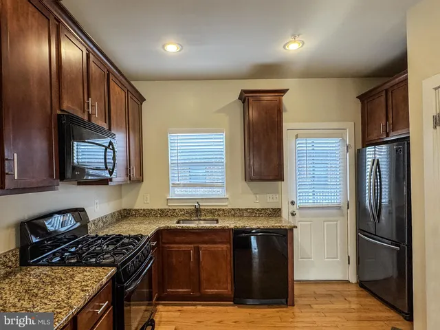 a kitchen with granite countertop stainless steel appliances and wooden cabinets