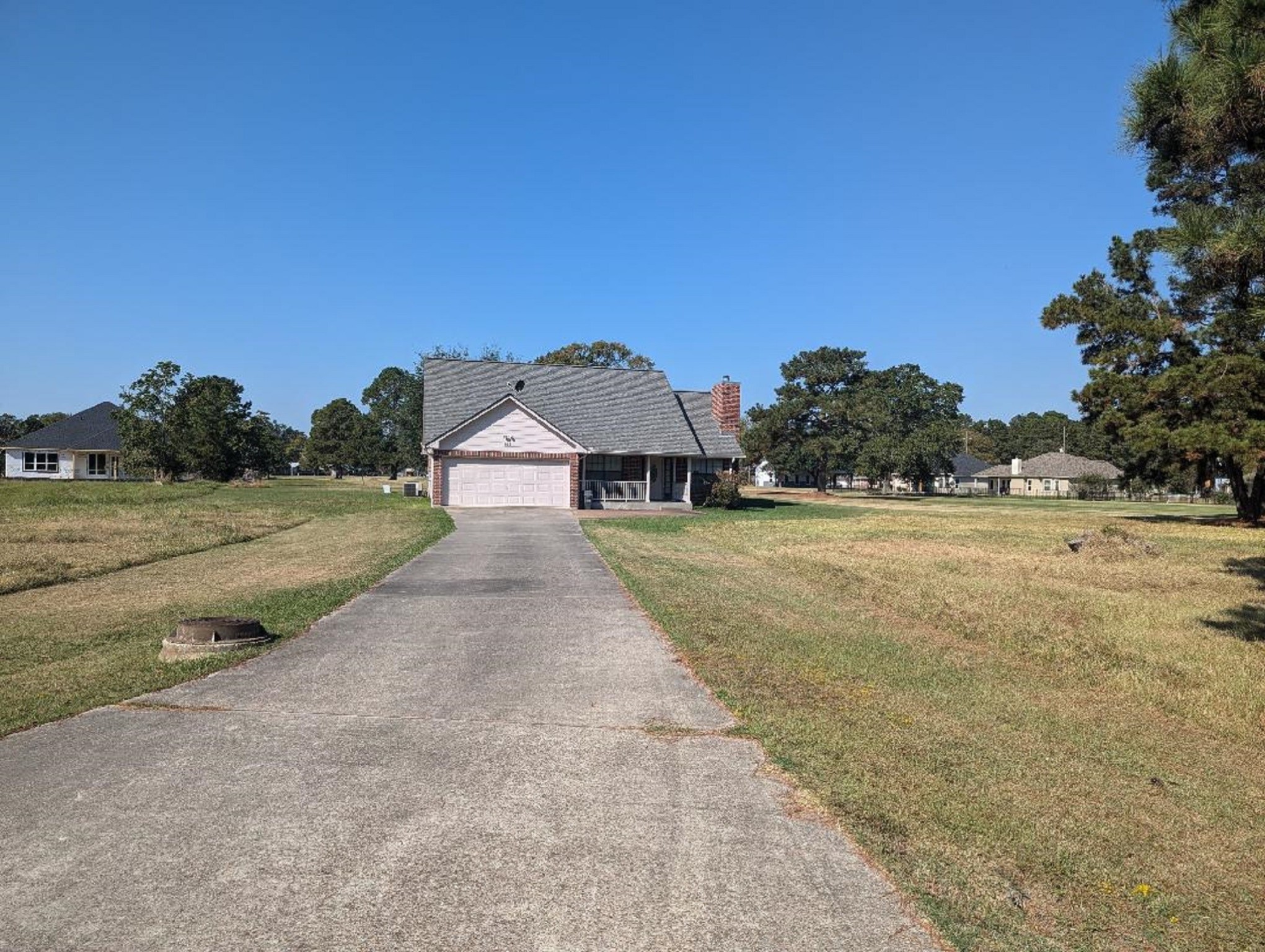 a front view of a house with a yard and trees