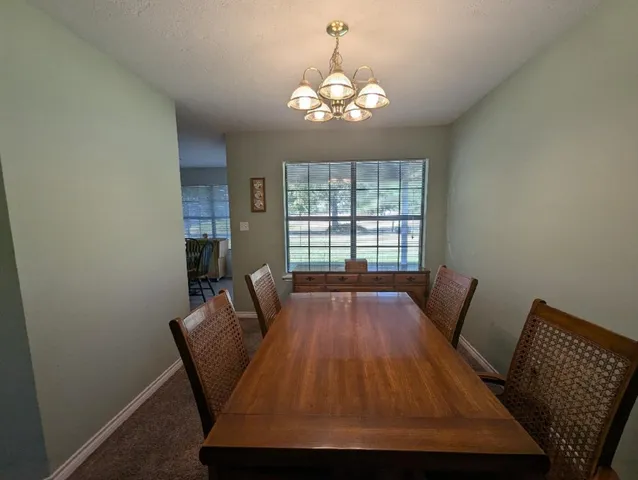 a view of a dining room with furniture and chandelier