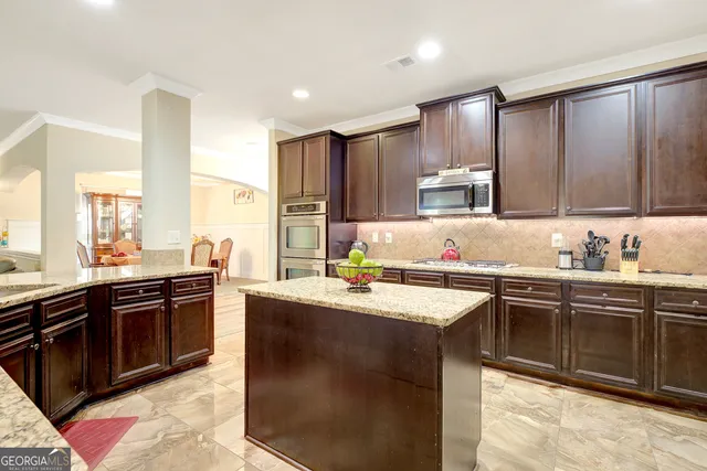 a kitchen with stainless steel appliances granite countertop a sink stove top oven and refrigerator