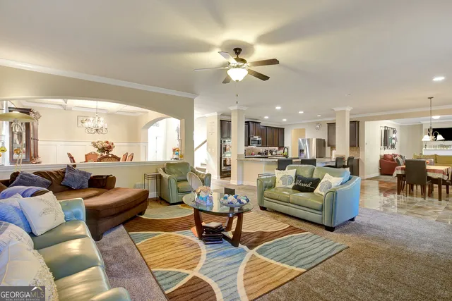 a living room with furniture kitchen view and a chandelier