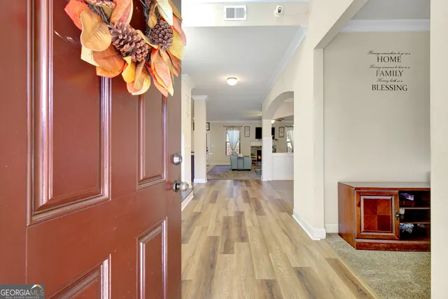 a view of a hallway with wooden floor and a chandelier