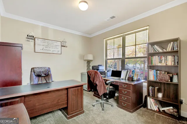 a view of a workspace with furniture and a window