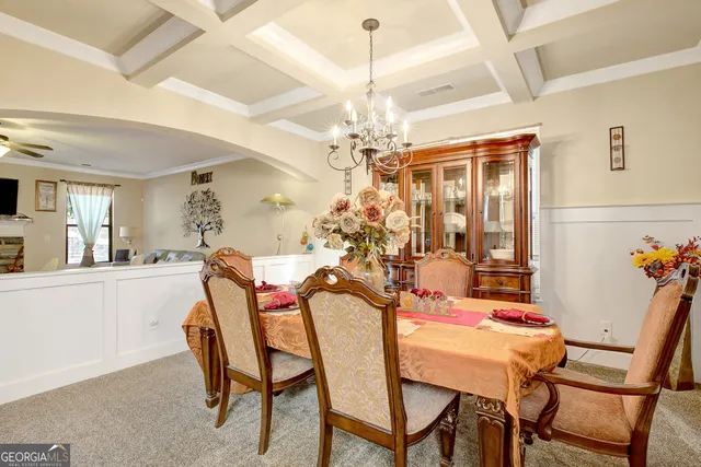 a view of a dining room with furniture and a chandelier