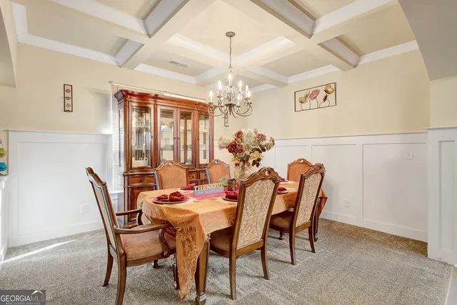 a dining room with furniture a chandelier and a rug