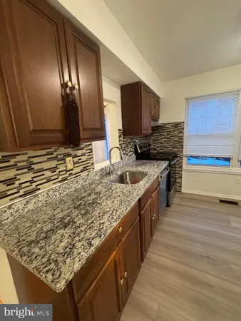 a kitchen with stainless steel appliances granite countertop a sink stove and cabinets
