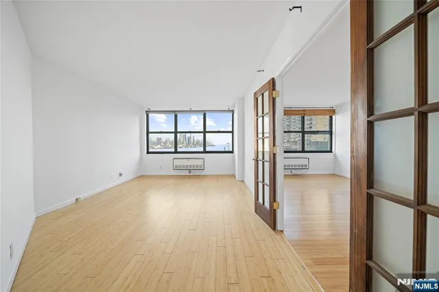 a view of an empty room with wooden floor