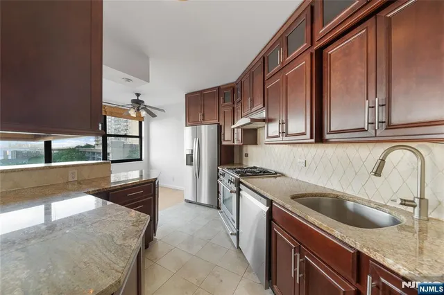 a kitchen with stainless steel appliances granite countertop a sink and a stove
