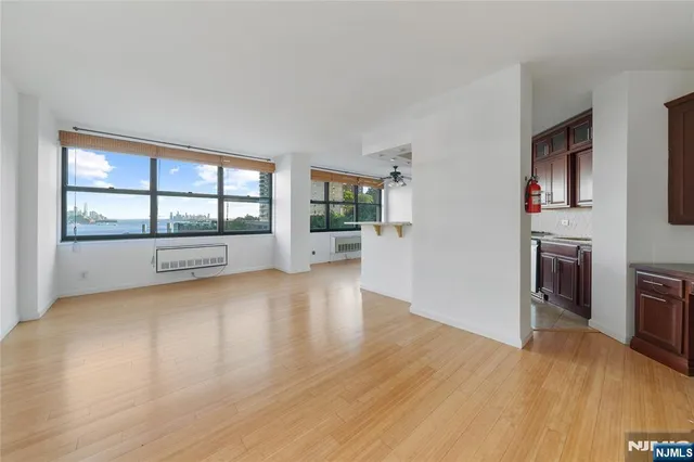 a view of empty room with wooden floor and fireplace