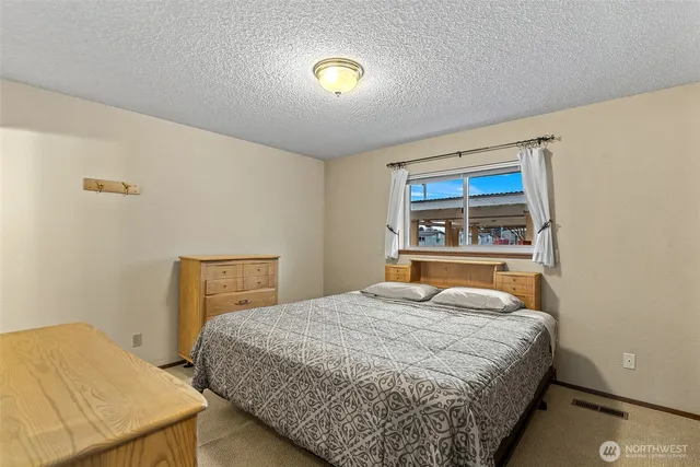 a bedroom with a bed and a dresser with sliding door