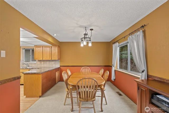 a dining room with furniture a chandelier and window