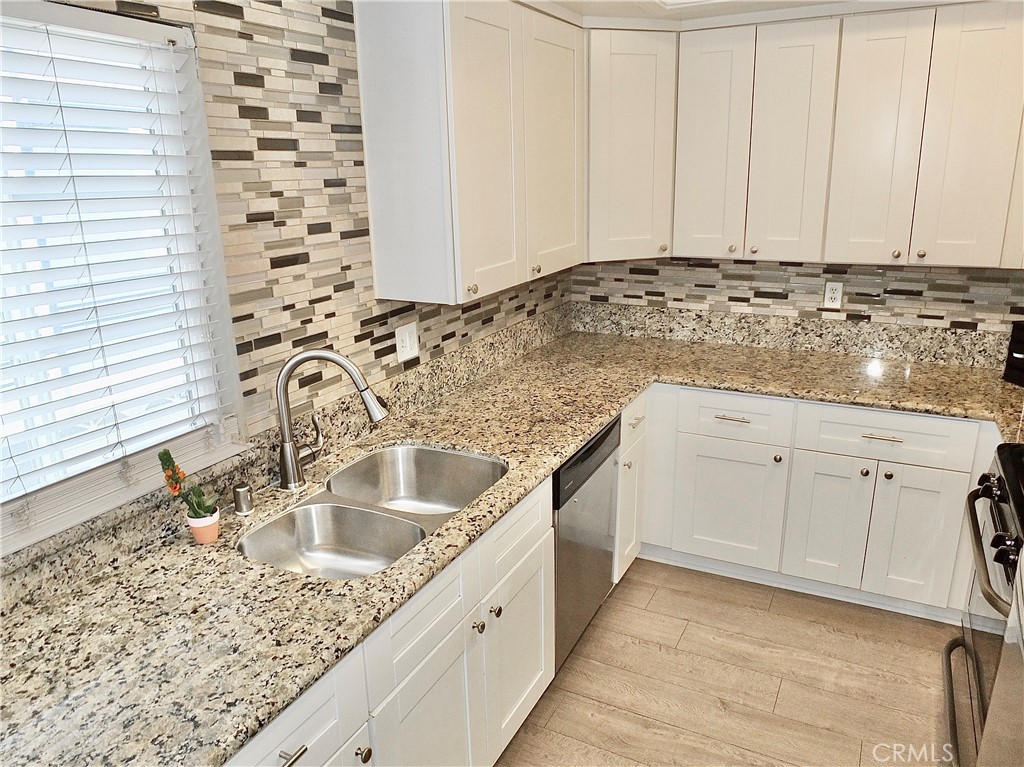 117 West Spring Street, Unit E Long Beach, CA 90806 - Photo 14 of 44 a kitchen with granite countertop a sink and cabinets