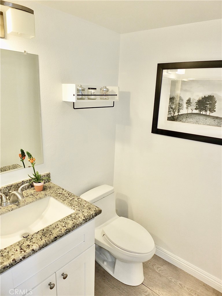 117 West Spring Street, Unit E Long Beach, CA 90806 - Photo 15 of 44 a bathroom with a granite countertop sink mirror vanity and toilet